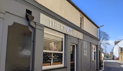 A grey pub with a blue sky